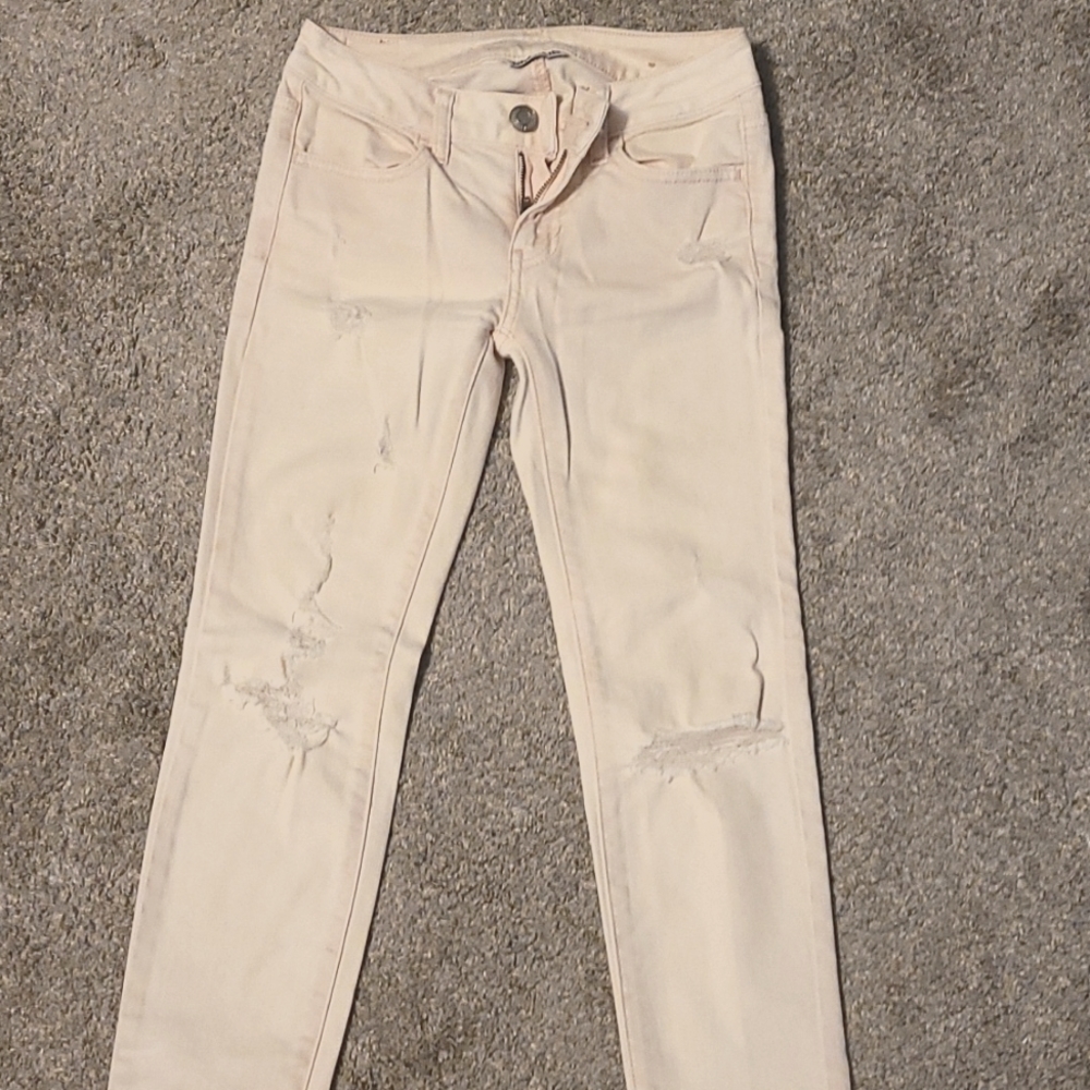 American Eagle Super stretch distressed jeans. They are light pink and size 00
